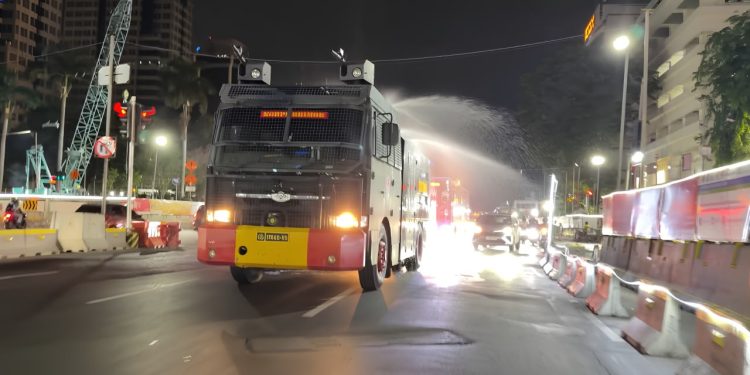 Brimob PMJ Semprot Jalan dan Bagikan Masker ke Warga
